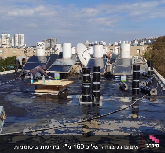 עובדים על גג עם יריעות איטום וכלי עבודה